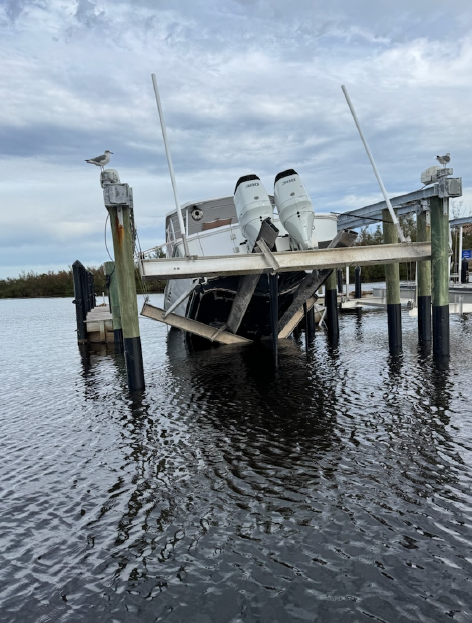 Failing boat lift with boat on bunks that has collapsed